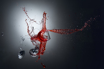 Collision of wine glasses with shattered glass and wine splash