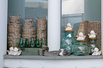 Wooden birds, wicker baskets, ceramic angels, flowerpots, glass bottles and  jars in a flower shoprs in a flower shop