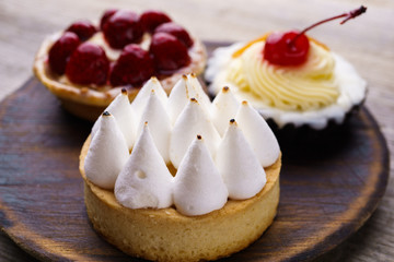 dessert background, assortment of delicious cakes. cream cheese cupcake, berry tart, lemon meringue tart and cookies made by pastry chef. delight, confectionery, sweets
