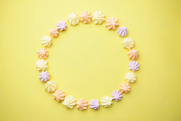 sweets, dessert, delight, confectionery. colorful meringues on yellow background. minimal food concept. creative layout, banner or poster template with copy space