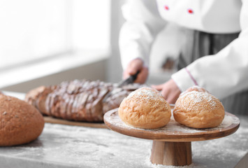 Stand with fresh buns on table in bakery