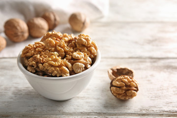 Bowl with walnuts on light table