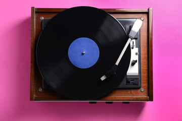 Obraz premium Record player with vinyl disc on color background