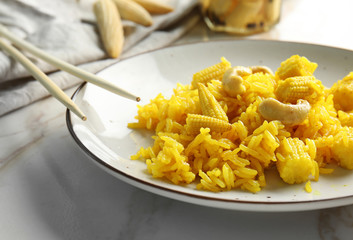 Plate with tasty rice, corn and nuts on light table