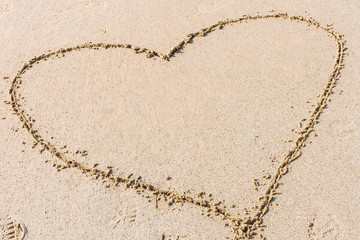 Heart shape drawn on sandy beach. Concept of love, romantic relationship