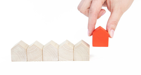 A female(woman) hand pick up a wood house isolated white  background