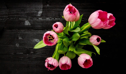 bouquet of tulips in vase on wooden table