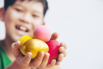 Fototapeta na wymiar Child showing colorful Easter eggs happily - Easter holiday celebration concept