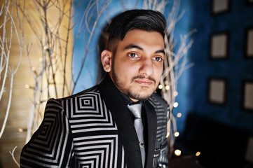 Close up portrait of young indian handsome business man at evening suit and tie on restaurant.