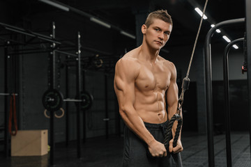 Fototapeta na wymiar Handsome guy training triceps in gym pumping up body bodybuilding athlete