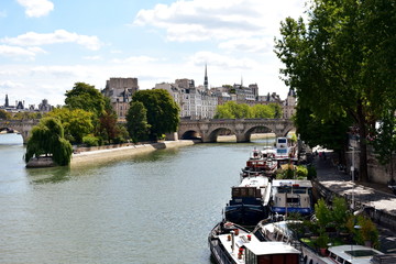 Paris, France. Seine River with boats and Ile de la Cite from Pont des Arts. View of Vert Galant...