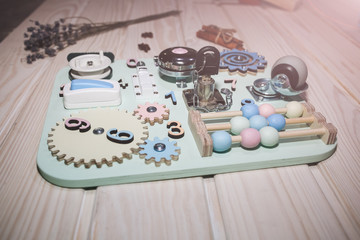 Children busy board with different tools for kids developing. Eco-friendly wooden unique toys for playing.
