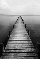 Fototapeta premium Drewniane molo nad jeziorem ciszy, strzelanie monochromatyczne