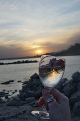 wineglass glass on the background of the sunset sea and roses wineglass