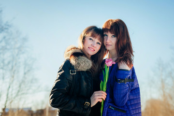 Portrait of two beautiful girls against a clear spring sky