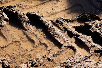 Heavy machinery tyre track impressions in mud on construction site 