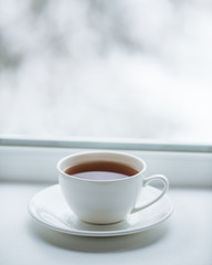 Cup with coffee, tea on the background of the winter landscape.