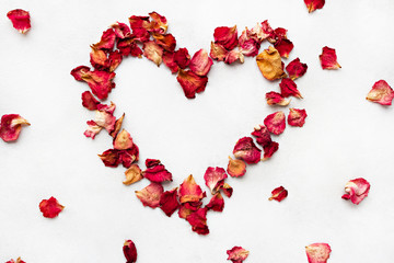 Red rose petals are shaped in a romantic heart pattern