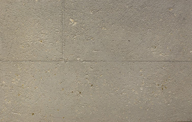 Photo of old gray cement wall with fractures.