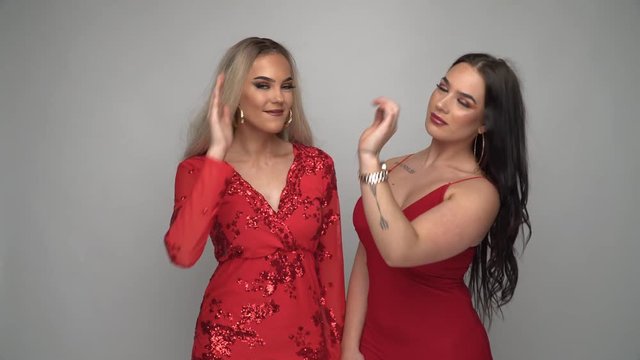 Zwei junge Frauen im roten Kleid Reaktion Abklatschen