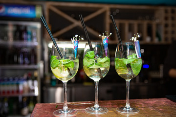 fresh mojito cocktail in glasses on bar background