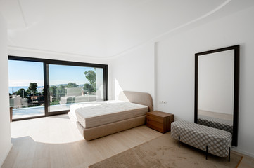 Fototapeta na wymiar Minimalistic style bedroom in brown and beige tones with new mattress.