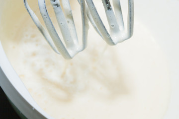 Sugar is mixed with beaten egg for dessert