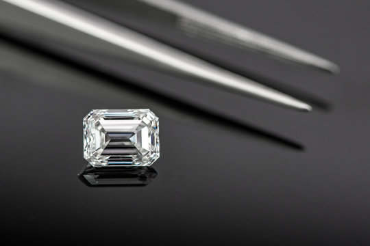 Emerald Cut Diamond With Tweezers On Black Reflection Back Ground