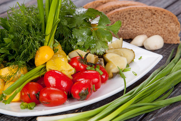  juicy, summer vegetable salad cutting from fresh vegetables and greens in a beautiful serving on a wooden table for decoration and design