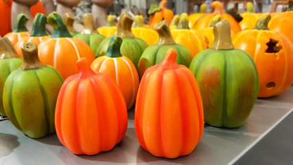 Group of hand painted colorful decoration clay pumpkins for Halloween on a grey table