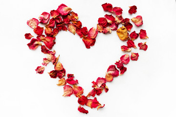 Heart made of rose petals. Red rose petals heart over white background