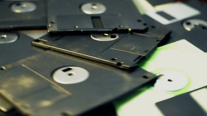 Overhead shot pile of old-style 3.5-inch floppy disk rotating - Powered by Adobe