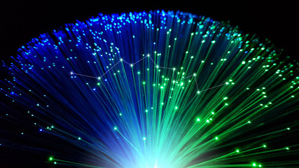 Blue and green optical fiber cables with shining tips on a black background