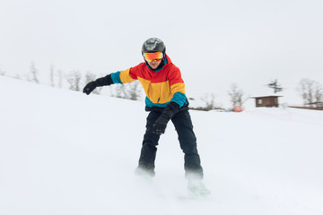 Fototapeta na wymiar young stylish snowboarder trying to take a balance, full length photo.athlete skiing down