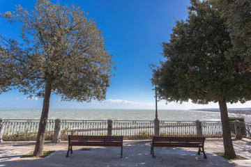 Empty benches at panoramic terrace over the sea.  Numana Sirolo, Ancona Mount Conero Marche Italy - beautiful tiny pearl of the Adriatic Sea with panoramic terrace over the sea.