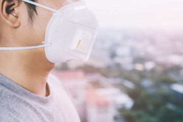 Portrait of man wearing facial hygienic mask nose outdoors. Ecology, air pollution car, Environmental and virus protection concept flu health against toxic dust covered the city of a health effect.