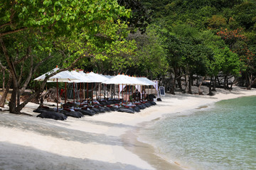 Bean bags with the white umbrella on the beach, set up for lunch at tropical island