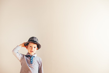 Nice and handsome boy with an elegant hat, isolated background in white with copy space.