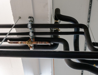 metal and plastic pipe system on the cellar ceiling of an apartment building