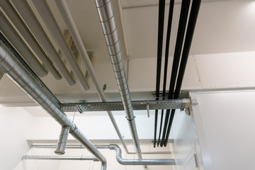 metal and plastic pipe system on the cellar ceiling of an apartment building