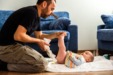 Dad with a pincer on his nose so he does not smell the smell of his daughter's diaper while he...