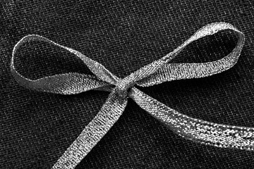 Gift concept - Silver bow and ribbon on grey background