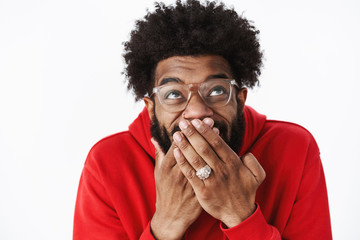 Waist-up shot of delighted happy african american male bearded friend in glasses chuckling,...