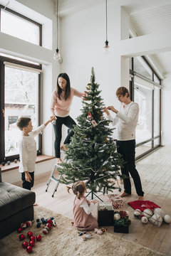 New Year. Decorate the Christmas tree. Artificial tree. A girl i
