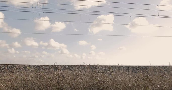 Treno in transito vista laterale dal basso della ferrovia.