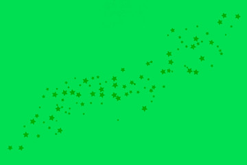 Decorative stars on a green background. Concept of the night sky. Can be used as wallpaper or background. Flat lay, top view