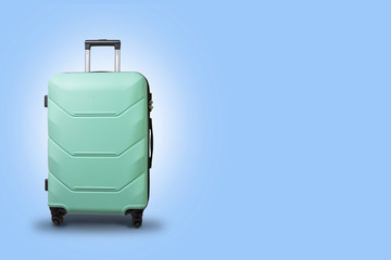 Light Green Suitcase on wheels on a light blue background. Travel concept, vacation trip, visit to relatives