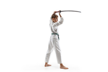 Teen boy fighting at Aikido training in martial arts school. Healthy lifestyle and sports concept. Fightrer in white kimono on white background. Karate man with concentrated face in uniform.