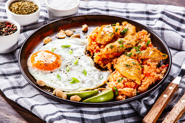 Grilled chicken meat with groats and fried egg on wooden table