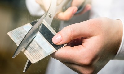 Cutting up credit card with scissors